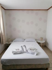 a bed with two white slippers on top of it at Anae in Saint-André