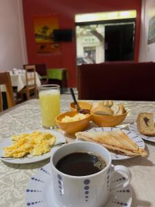 a table with breakfast foods and a cup of coffee at Hotel Centro Villarrica in Villarrica