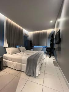 um quarto de hotel com uma cama e uma televisão em Fortpraia Hotel em Fortaleza