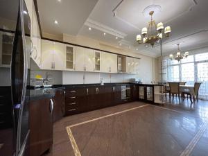 a large kitchen with wooden cabinets and a dining room at Megafun Sea View in Baku