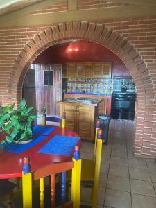 a kitchen with a table and a brick wall at Casa Gutiérrez in Teotitlán del Valle