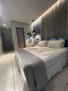 een slaapkamer met een groot bed met witte lakens bij Fortpraia Hotel in Fortaleza