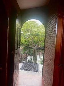 un arco que conduce a un balcón con un árbol en Casa Gutiérrez en Teotitlán del Valle