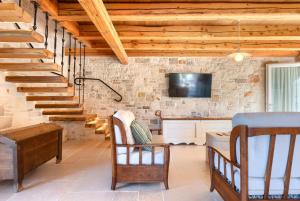 a living room with wooden stairs and a tv at Rustic villa Krug with panorama view in Buje in Bibali