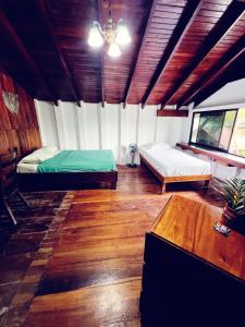 a room with two beds and a table in it at Perla Negra Beachfront in Puerto Viejo