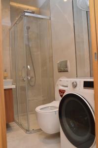 a bathroom with a toilet and a washing machine at Unca in Belgrade +11 photos