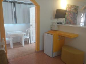 a small kitchen with a small table and a desk at Pousada Vila Magiosa in Búzios