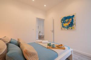 un salon avec un canapé bleu et un tableau dans l'établissement Trendy Spacious Flats - Matosinhos, à Matosinhos