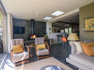 a living room with a couch and chairs and a fireplace at The Carriage House in Lyme Regis