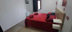 a bedroom with a red bed and a staircase at Pollino House in Morano Calabro