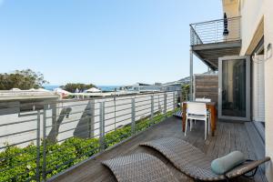 uma varanda com uma mesa e cadeiras e o oceano em Caprice Court 6 na Cidade do Cabo