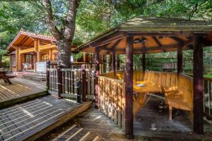 a wooden gazebo with a table and a bench at Beaver Creek Lodge in Aviemore +13 photos