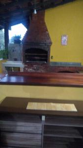a brick oven in a room with a yellow wall at POUSADA YHWH (Pedro & Neth) in Araruama