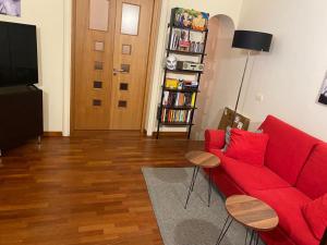 ein Wohnzimmer mit einem roten Sofa und einem TV in der Unterkunft Donna Ada al Duomo in Salerno