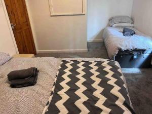 a room with two beds and a bag on the floor at Cosy 2 Bed House in Rochdale in Rochdale