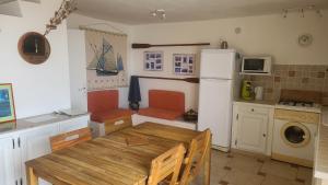 una cocina con mesa y una cocina con refrigerador en CABANON SEVERIN, en Canari 7 fotos más