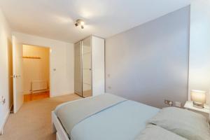 a white bedroom with a bed and a walk in closet at Lavish Brick Lane & Shoreditch London Apartment in London