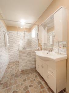 La salle de bains blanche est pourvue d'un lavabo et d'une douche. dans l'établissement JOE'S CASTLE, à Sagbayan