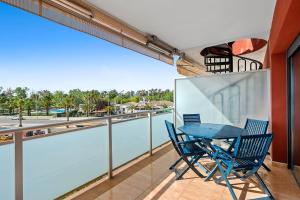 un balcón con una mesa azul y sillas. en Appartement de vacances avec vue mer , terrasses , solarium et Wi-Fi, en L'Eucaliptus