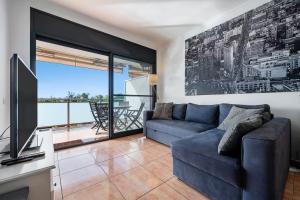 sala de estar con sofá azul y TV en Appartement de vacances avec vue mer , terrasses , solarium et Wi-Fi, en L'Eucaliptus