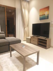a living room with a flat screen tv and a coffee table at Beautiful Golf & Sea View in As Sīfah