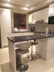 a kitchen with a counter and two bar stools at Beautiful Golf & Sea View in As Sīfah