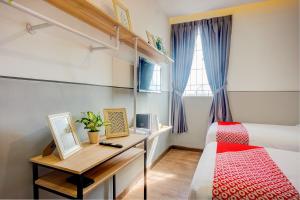 - une chambre avec un lit, un bureau et une fenêtre dans l'établissement SUPER OYO 93064 Alhesa Residence, à Medan
