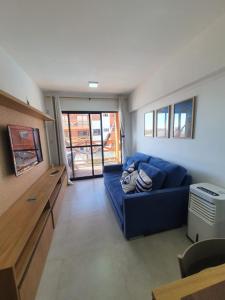 una sala de estar con un sofá azul en una habitación en Vila Atlântida 207B en Luis Correia