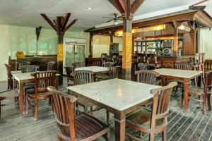 restauracja ze stołami i krzesłami w pokoju w obiekcie Collection O 91081 New Arena Hotel w mieście Kuta