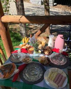 uma mesa coberta com pratos de comida numa mesa em Pousada Villa Cachoeira em Carrancas