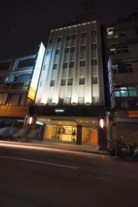 ein beleuchtetes Gebäude in der Nacht auf einer Stadtstraße in der Unterkunft Lio Hotel - Taipei Main Station in Taipeh