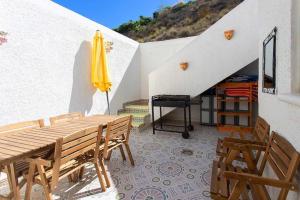 eine Terrasse mit einem Tisch und einem gelben Sonnenschirm in der Unterkunft CH Marquesa Golf (Ciudad Quesada) in Rojales