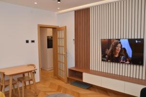 a living room with a flat screen tv on a wall at Unca in Belgrade