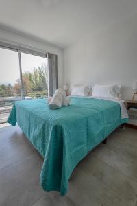 sypialnia z dużym łóżkiem i zielonym kocem w obiekcie Preciosos departamentos en Ruta del Vino, zona de viñedos y bodegas w mieście Lujan de Cuyo