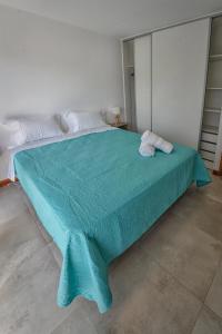 a bedroom with a large bed with a blue blanket at Precioso departamento en Ruta del Vino, zona de viñedos y bodegas in Ciudad Lujan de Cuyo