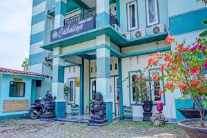 un edificio azul y blanco con esculturas delante en OYO 91731 Home Stay Elis Cateliya Syariah, en Karawang