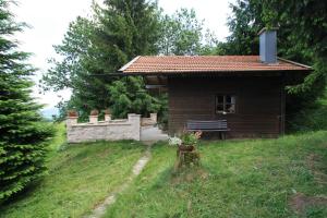 una pequeña casa con un banco en un patio en Bernerhof Ferienwohnungen Schmuck, en Teisendorf