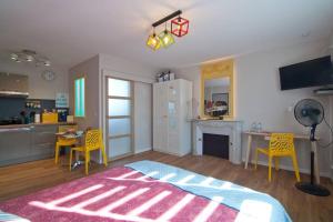 un soggiorno con tavolo e sedie e una cucina di Le petit Marcel - Saint-Julien-les-Villas a Saint-Julien-les-Villas Altre 5 foto