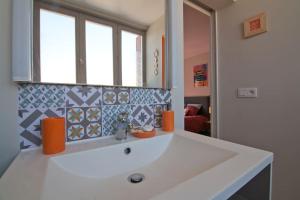 ein Badezimmer mit einem weißen Waschbecken und einem Spiegel in der Unterkunft Le petit Marcel - Saint-Julien-les-Villas in Saint-Julien-les-Villas