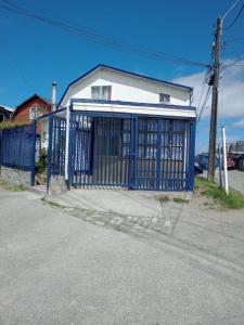 una puerta azul frente a una casa blanca en Alojamiento a pasos del hospital, en Puerto Montt