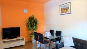 a living room with a table with chairs and a television at One bedroom appartement with shared pool enclosed garden and wifi at M'bour 2 km away from the beach in Mbour