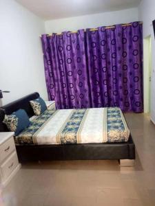 a bedroom with a bed and purple curtains at One bedroom appartement with shared pool enclosed garden and wifi at M'bour 2 km away from the beach in Mbour