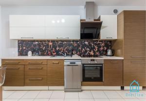 a kitchen with wooden cabinets and a mural of people on the wall at Direct Room in Gdańsk