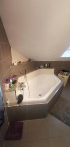 eine große weiße Badewanne in einem Zimmer mit in der Unterkunft Chez manu in Voellerdingen