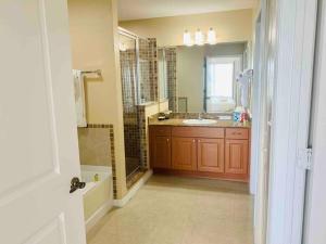 a bathroom with a sink and a shower and a mirror at Walking Distance from Universal One Bedroom Resort in Orlando