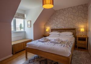 a bedroom with a bed with two towels on it at Taigh a'Chaorainn in Spean Bridge