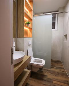 a bathroom with a white toilet and a sink at Moments Villas Premium, Prevalle in Prizren