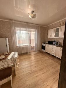 an empty kitchen with a table and a refrigerator at 1 комнатная квартира, in Kokshetau