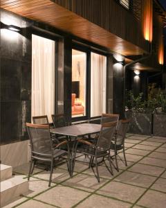 a dining table and chairs on a patio at Moments Villas Premium, Prevalle in Prizren