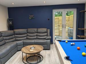 a living room with a couch and a pool table at Bowness - 3 Bed - Hot Tub House in Bowness-on-Windermere